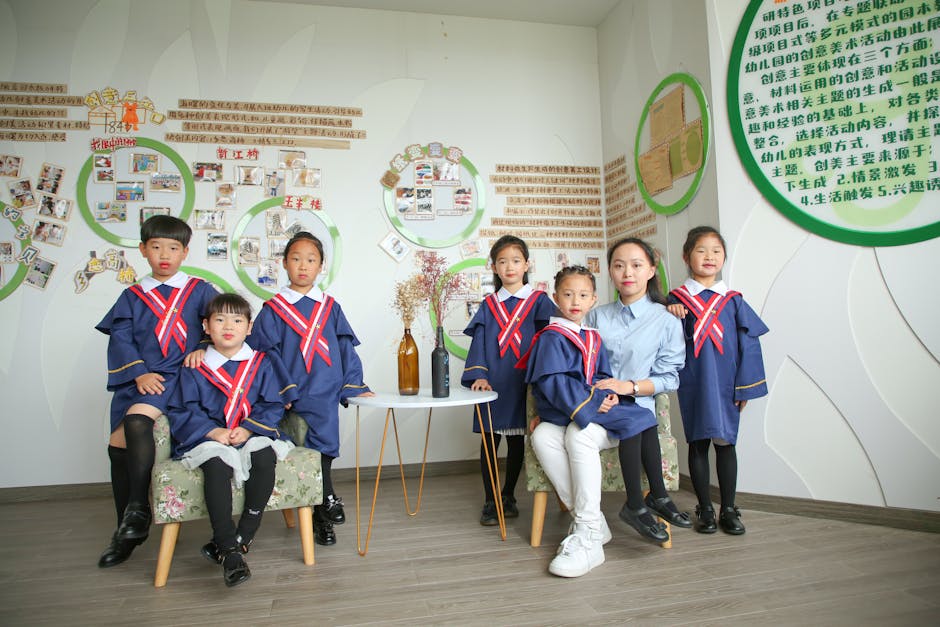 Group of children in academic gowns with teacher indoors