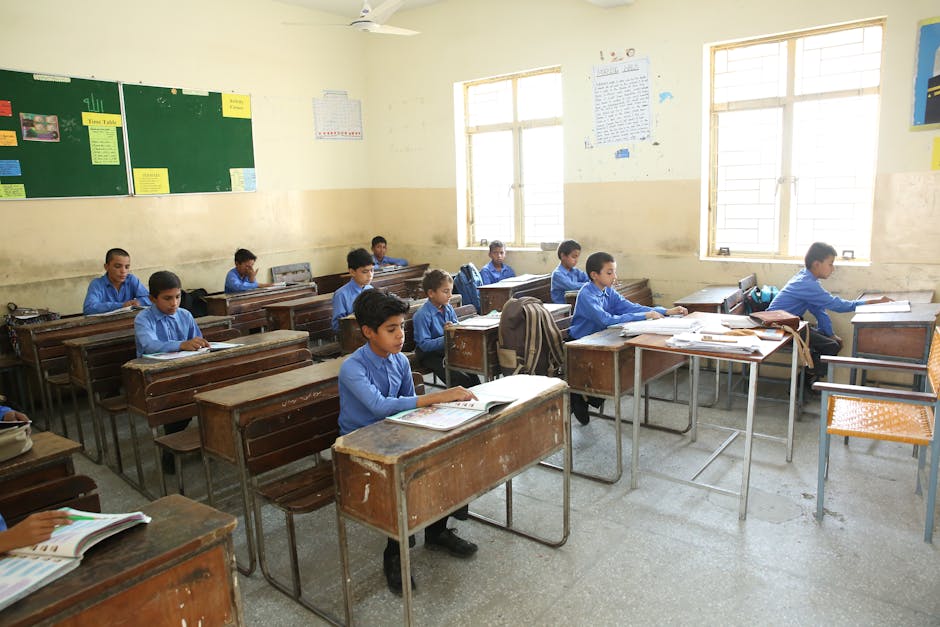 A group of young boys studying in a bright classroom filled with educational posters